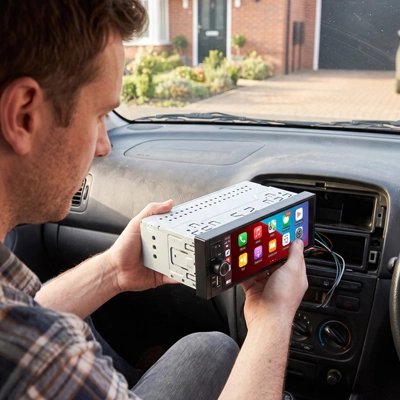 Autoradio carplay tenu par un homme dans une voiture